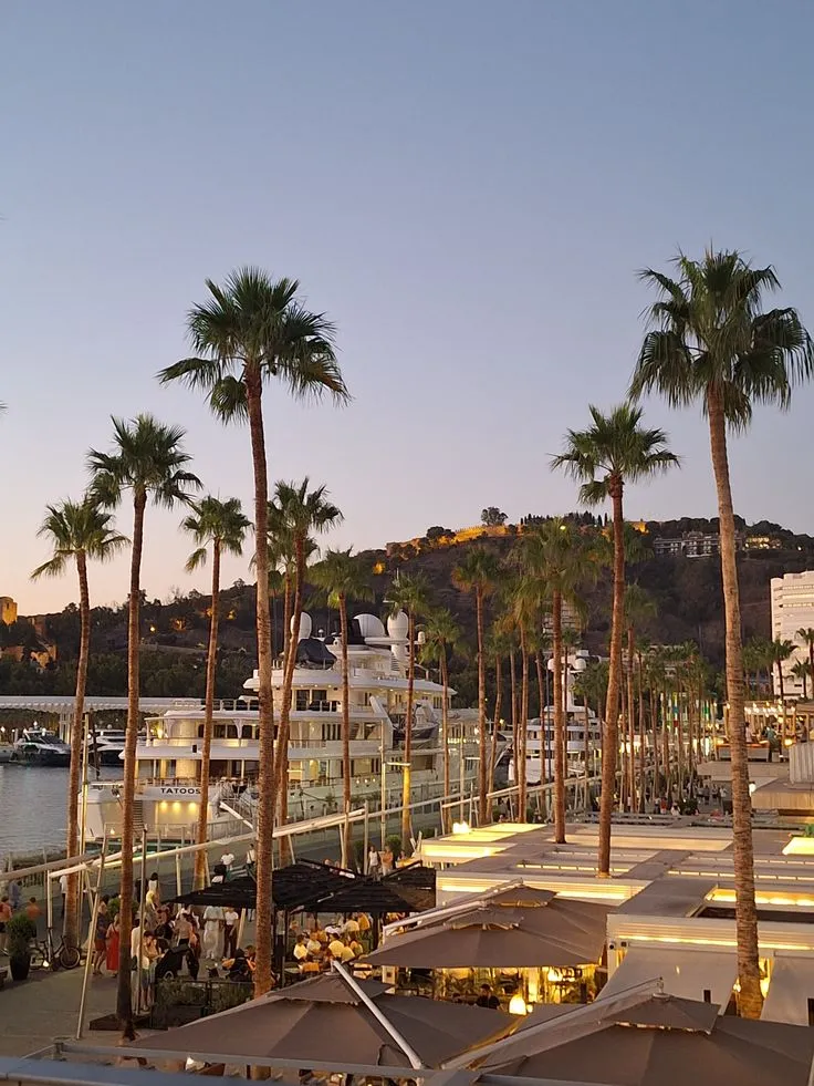 People at the Muelle Uno waterfront bars on the port at dusk